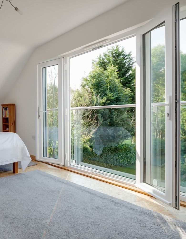 غرفة نوم بأبواب UPVC بيضاء مفتوحة على الحديقة